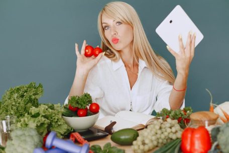 Vlogger promoting healthy eating with fresh vegetables on the table.