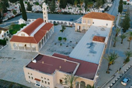 Stunning aerial view of a church with red roof in an urban setting surrounded by greenery.